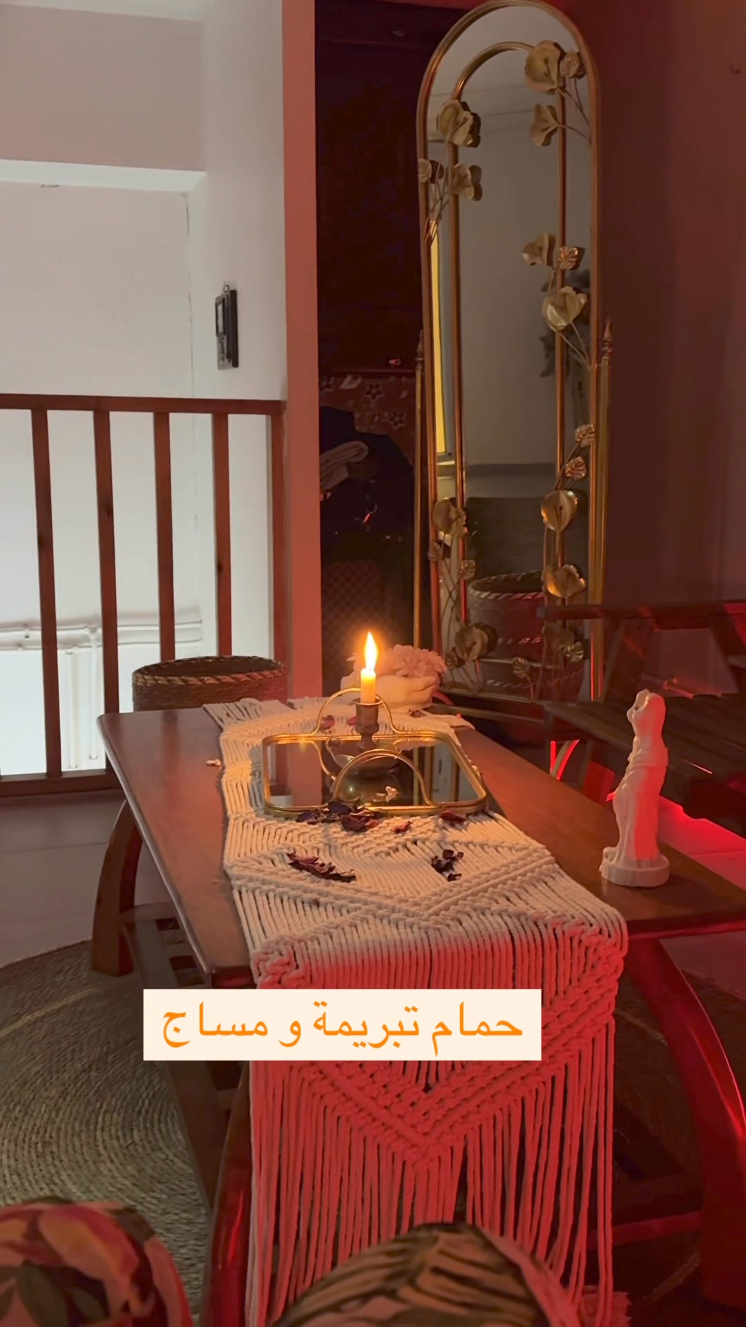 Intérieur du hammam — table en bois, miroir doré et bougies